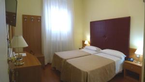 Postel nebo postele na pokoji v ubytování Hotel Centrale Byron