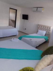 a room with two beds and a television in it at buenavista class in Barranquilla +2 photos