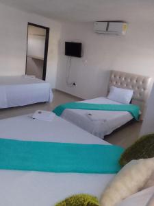 a room with two beds and a television in it at buenavista class in Barranquilla