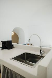 a kitchen with a sink in a white counter top at Kalyva Cycladic house - Oia Santorini in Oia