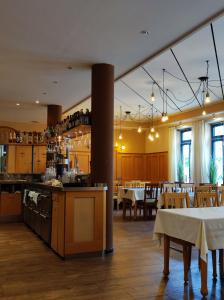 a restaurant with tables and chairs and a kitchen at Stadthotel Deggendorf in Deggendorf