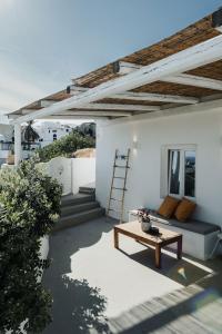 a patio with a couch and a table at Kalyva Cycladic house - Oia Santorini in Oia