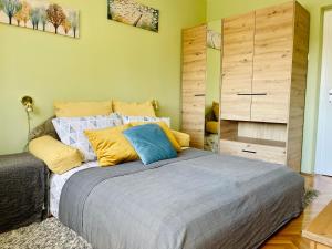 um quarto com uma cama com almofadas amarelas e azuis em Apartman Jelena II em Sremska Mitrovica