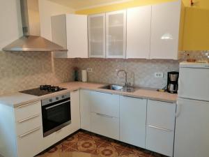 una cocina con armarios blancos y fregadero en Apartment Violeta, en Pula