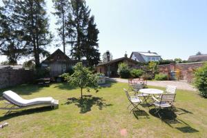 岑平的住宿－Am Rieck "Zirkuswagen"，一个带椅子和桌子的院子和一棵树