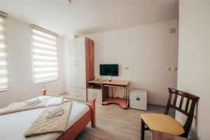 a bedroom with a bed and a desk with a television at Nestor Apartments in Bitola