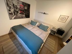 sypialnia z niebieskim łóżkiem z obrazem na ścianie w obiekcie Haus Berger w mieście Fuschl am See