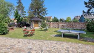 a ping pong table and chairs in a yard at Am Rieck "Fachwerkaus" in Zempin