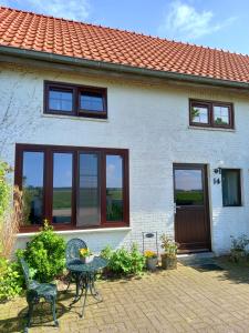 een huis met een tafel en stoelen ervoor bij Klakbaan 14 in IJzendijke