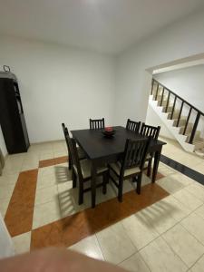 una mesa negra y sillas en una habitación con escaleras en Departamento SGO en Santiago del Estero