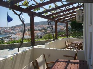 a balcony with tables and chairs and a view of a city at Vassiliki Studios in Andros