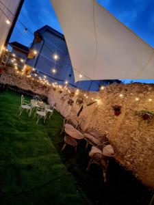 un patio con mesas, sillas y una sombrilla blanca en Hostaria Zerø HR en Piedimonte dʼAlife