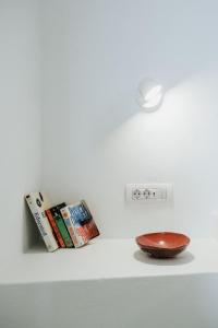 a shelf with a clock and a bowl on a wall at Kalyva Cycladic house - Oia Santorini in Oia