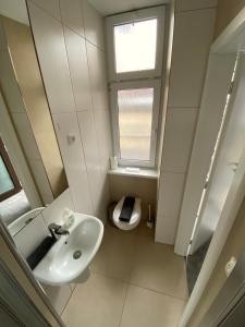 łazienka z umywalką i toaleta z oknem w obiekcie Family Lorenz & Coffee House w Pradze