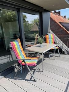 eine Terrasse mit 2 Stühlen und einem Tisch auf der Veranda in der Unterkunft Außergewöhnlich Ferienwohnung im Villenviertel in Wilhelmshaven