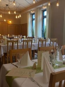 a dining room with white tables and chairs at Stadthotel Deggendorf in Deggendorf