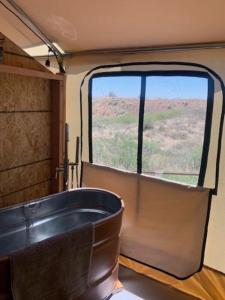 bañera en tren con ventana grande en Silver Spur Homestead Luxury Glamping -The Miner, en Tombstone