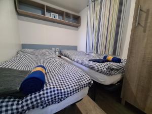 two twin beds in a small room with a window at Paradiso Rusinowo in Rusinowo