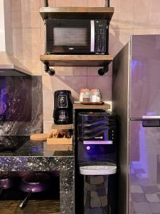 a kitchen with a refrigerator and a microwave at CLOCKWORKORANGE Luxury Suites in Mactan