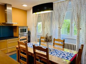 uma cozinha com uma mesa de jantar e uma mesa e cadeiras em Apartman Jelena II em Sremska Mitrovica