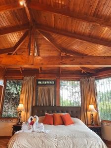 a bedroom with a large bed with two swans on it at Finca Paraiso Mountain Retreat near San Jose Airport in Birrí