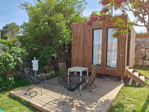 une terrasse en bois avec une table et des chaises devant une cabine dans l'établissement La Cabane de Lili Prune, à Goudargues