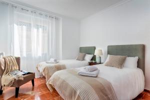 1 dormitorio con 2 camas y toallas. en Genteel Home Ático Gran Capitán en Granada