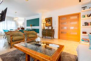 ein Wohnzimmer mit einem Sofa und einem Tisch in der Unterkunft Genteel Home Martinez Campos in Granada