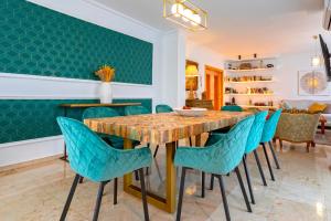a dining room with a wooden table and blue chairs at Genteel Home Martinez Campos in Granada