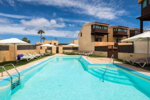duży basen z krzesłami i parasolami w obiekcie Las Tinajas No.6 w Corralejo