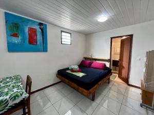 een slaapkamer met een bed in een kamer bij Kahea Ragni in Punaauia