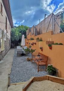 a patio with benches and a table and an umbrella at Idafe in Valdemaqueda