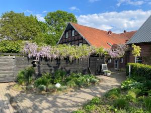 a garden in front of a house with purple flowers at Weberhof Apartment 3 in Münster