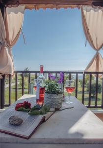 a table with a book and a glass of wine at BS Village in Metamorfosi