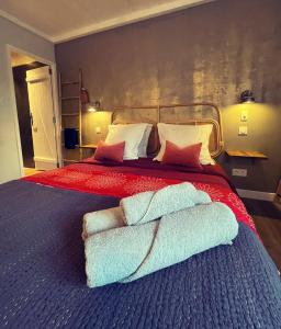 1 dormitorio con 1 cama con 2 toallas en Les Ecuries - 3 bedroom Gîte with plunge pool near Narbonne & the Canal du Midi, en Saint-Nazaire-dʼAude