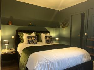 um quarto com uma cama grande e paredes verdes em O deux Cèdres em Les Arcs sur Argens