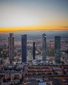 a group of tall buildings in a city at sunset at Paseo de la Castellana in Madrid