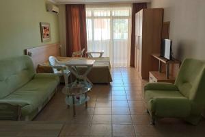 a living room with a couch and a table at Апартамент на метри от плажа in Sveti Vlas