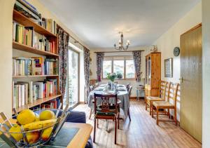a dining room with a table and bookshelves at Maes Mihangel in Llanfihangel-y-Pennant
