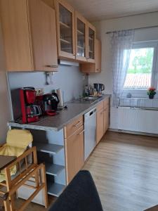 a kitchen with wooden cabinets and a counter top at Ferienwohnung Heck in Waldeck