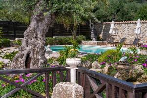 einen Garten mit einem Baum und einem Pool in der Unterkunft Art House Villa in Káto Yerakaríon