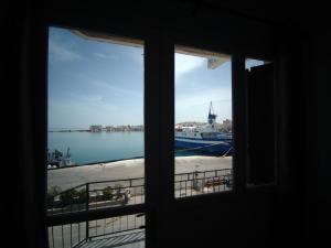 een raam met uitzicht op het water bij Omiros rooms in Chios