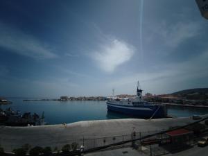 een grote boot is aangemeerd in een haven bij Omiros rooms in Chios