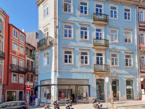 un bâtiment bleu avec des motos garées devant lui dans l'établissement Inspiring City Center 1BR Apartment, à Porto