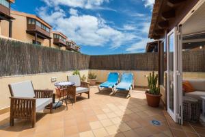 patio z krzesłami i kanapą na balkonie w obiekcie Las Tinajas No.6 w Corralejo