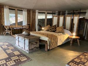 a bedroom with a bed with a wooden canopy at Double Tent - Dolly Farm & River Camp in Usa River