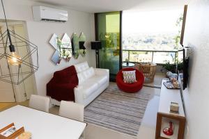uma sala de estar com um sofá branco e uma cadeira vermelha em Cielo Ejecutivo: Un hogar en la ciudad em Ciudad del Este