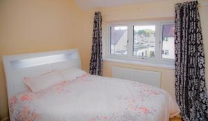 a bedroom with a bed and a window with curtains at White House in Netherton