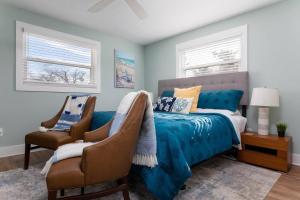a bedroom with a blue bed and two chairs at Beach Getaway at Jax Beach Studio Apartment in Jacksonville Beach