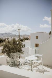 una mesa y sillas en un balcón con vistas en Hotel Thirasia en Fira